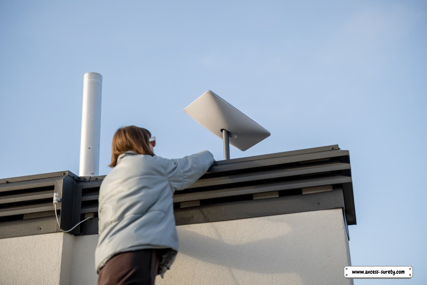 Starlink satellite dish installation on the roof by a woman.