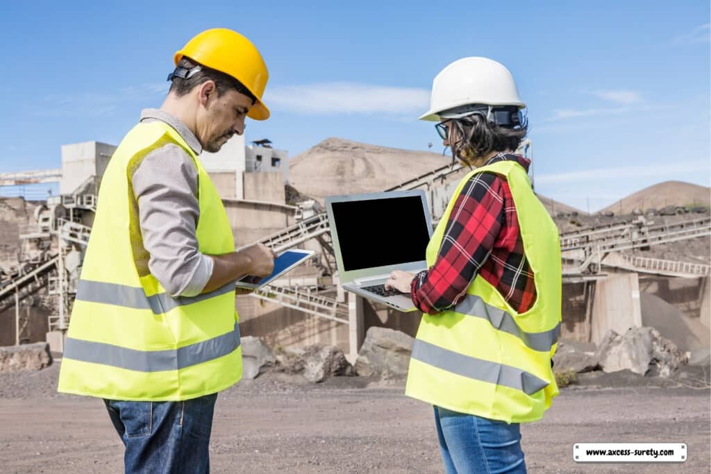 Standing in front of the historic building are a female coworker typing on a laptop and a guy engineer using a tablet.