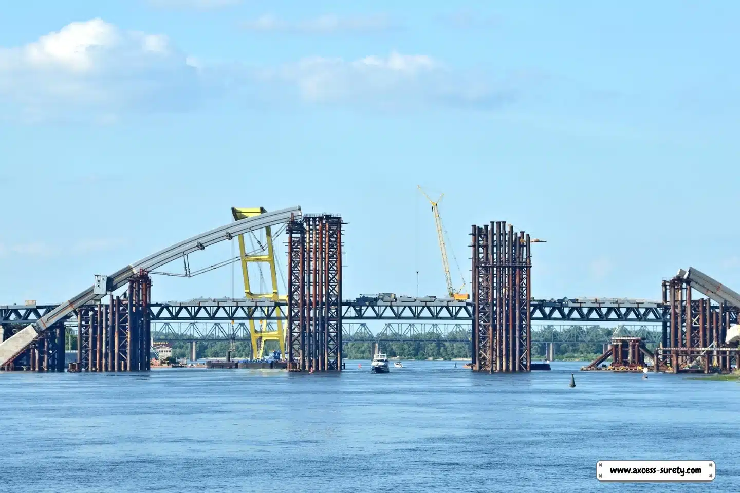 Cranes and boats at a bridge construction site.