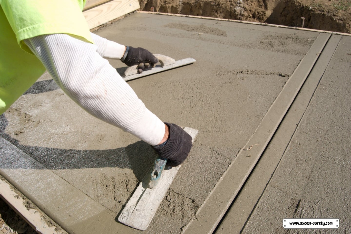 For seamless production, a worker completed a cement walkway.