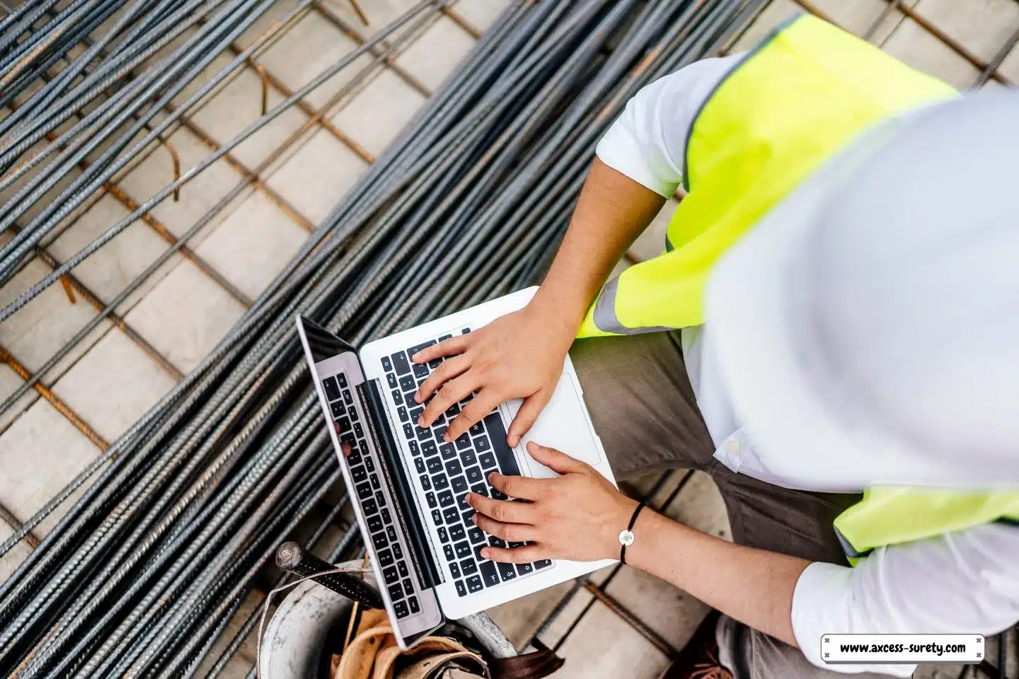 At the building site, a construction engineer uses a laptop to write reports.