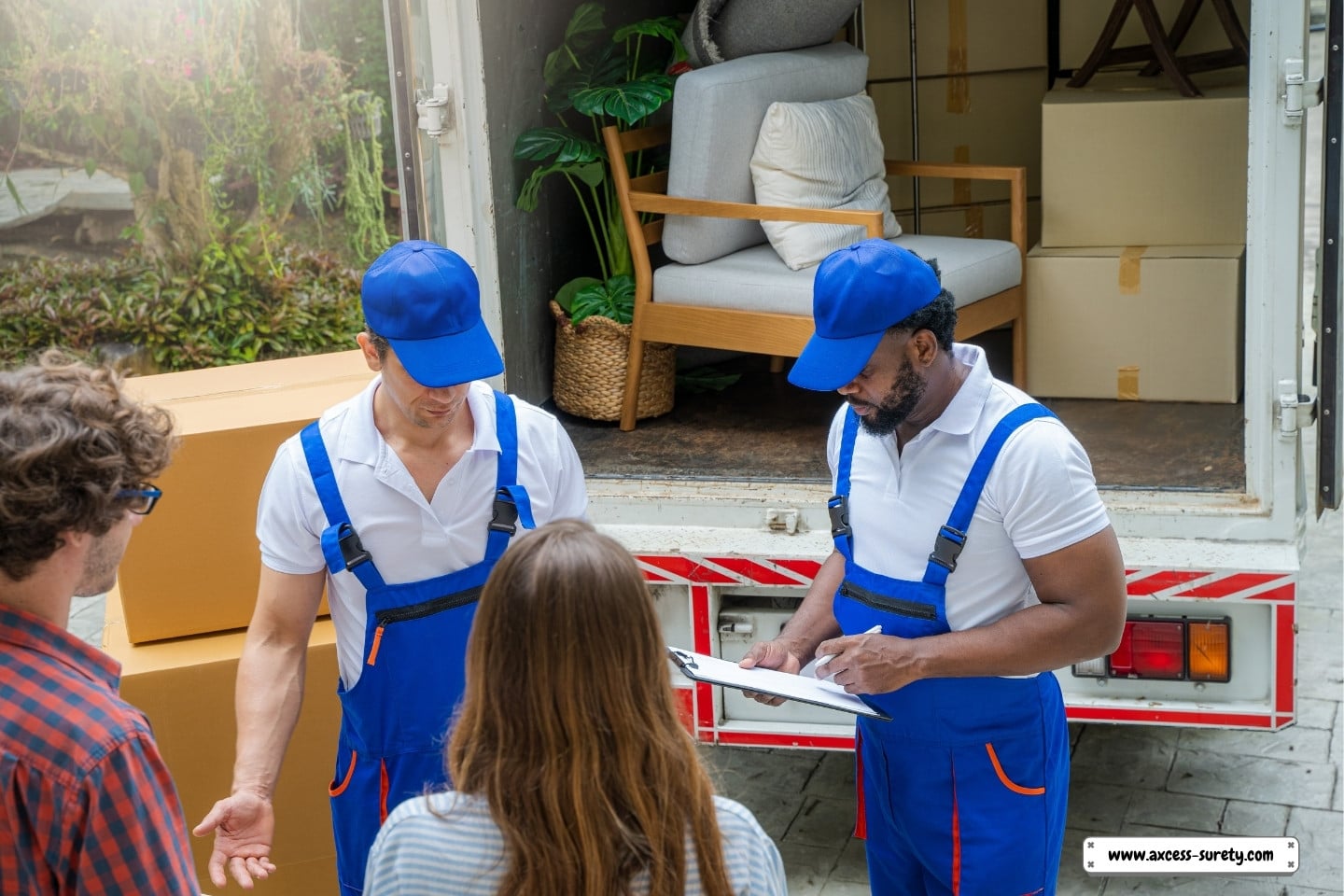 A happy couple in their new home with moving boxes. Check boxes for firm employees are being moved on a truck.