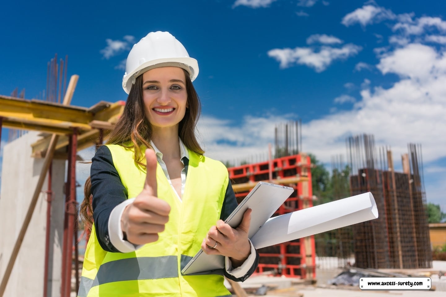 At the construction site, a contented female construction foreman is giving the thumbs up.