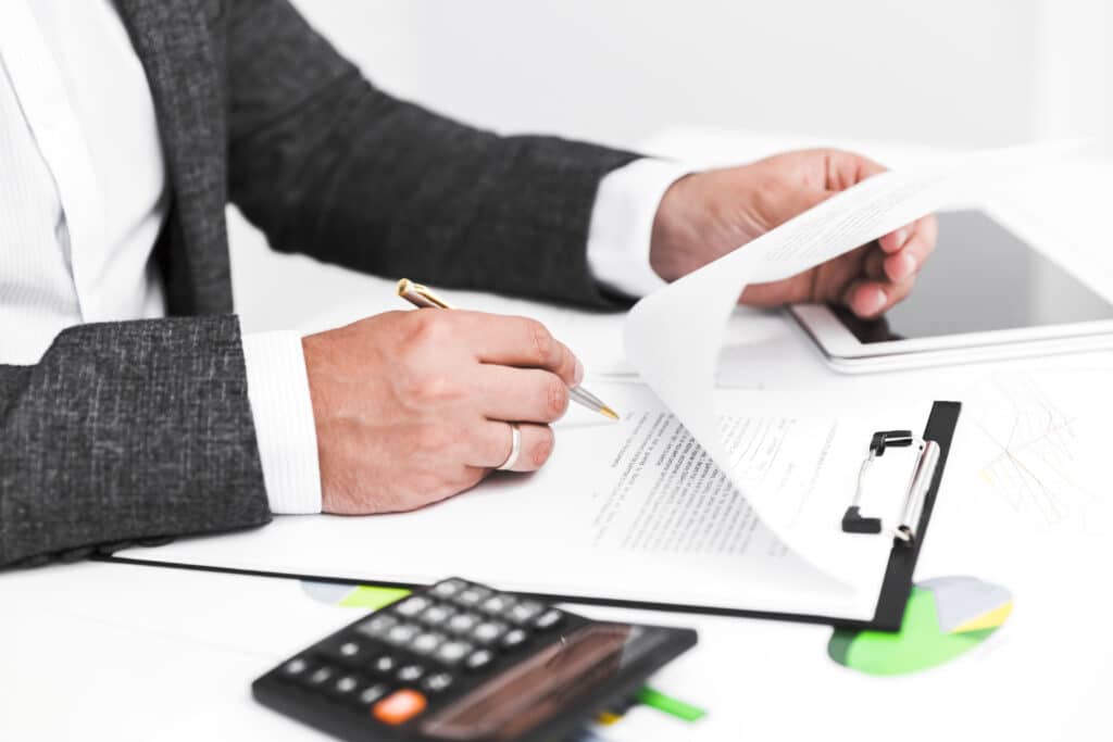 a person holding a pen and paper
