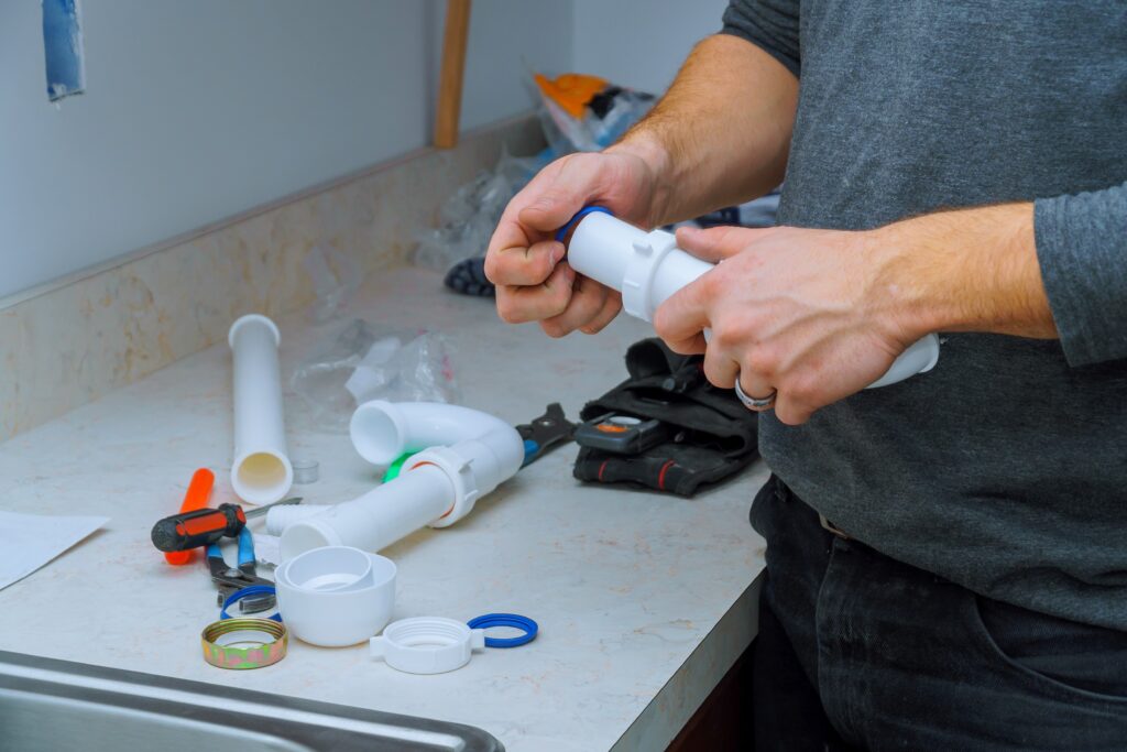 Plumber fitting pipes of tools and equipment in assemble and install a kitchen sink