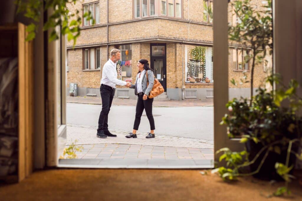 senior-man-and-woman-shaking-hands-on-city-street-2023-11-27-05-10-57-utc_11zon