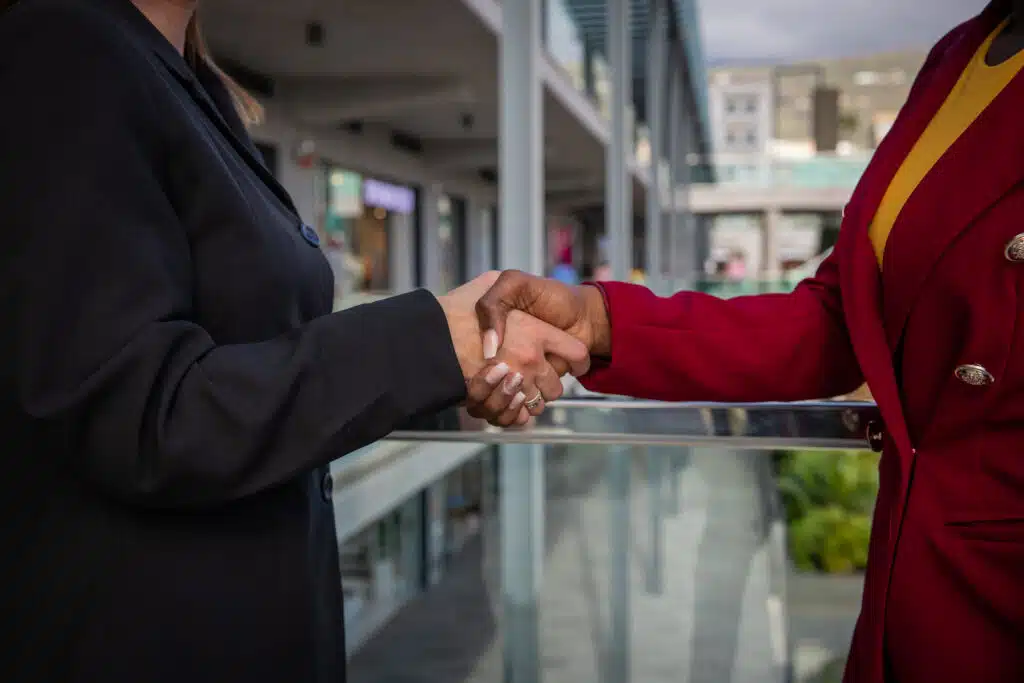 Two businesswomen, caucasian and african shaking hands, done deal concept