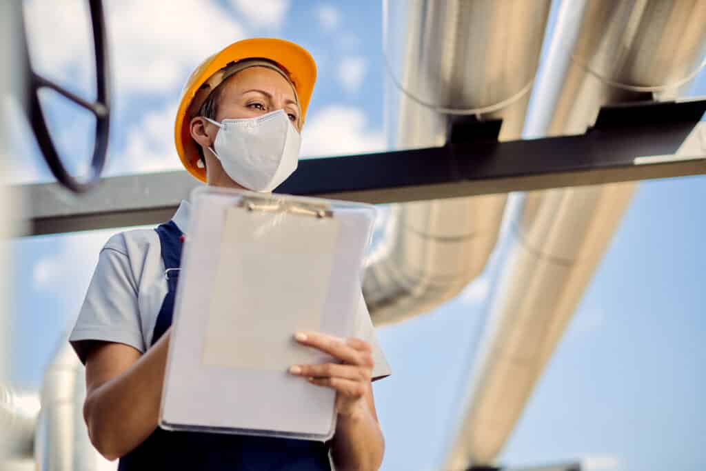 a woman wearing a hard hat and face mask