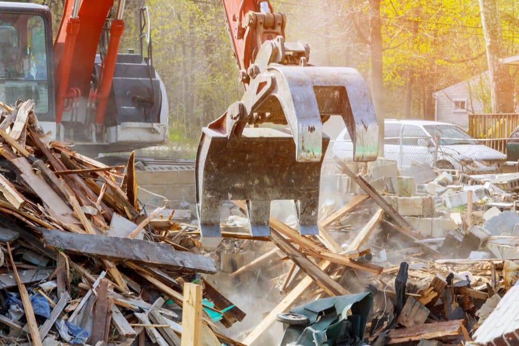 Demolition of an old house, wooden planks and rubble and the ruins of the house for new construction project.