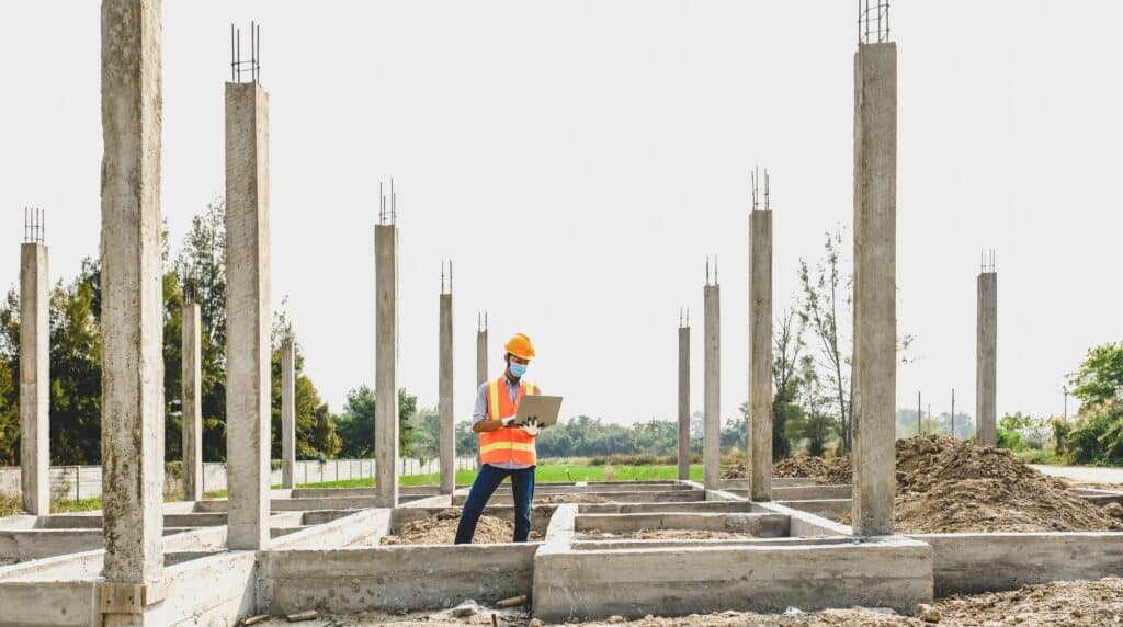 Engineer contractor man use lptop work safety industry project, check house plan design and investigating the size and quality in building construction structures site.