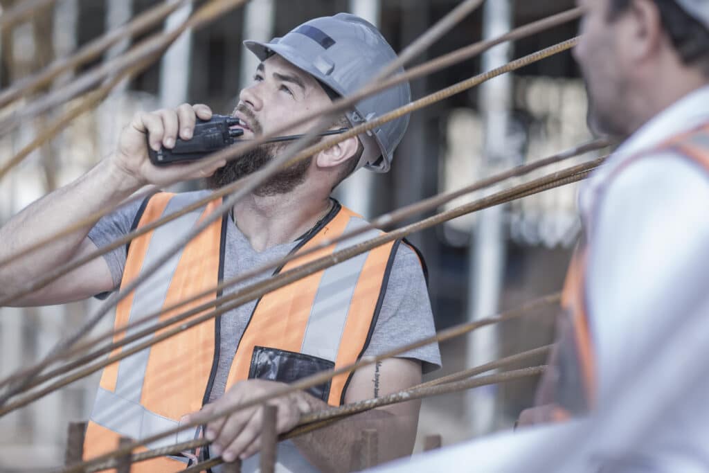 Site manager using walkie talkie on construction site