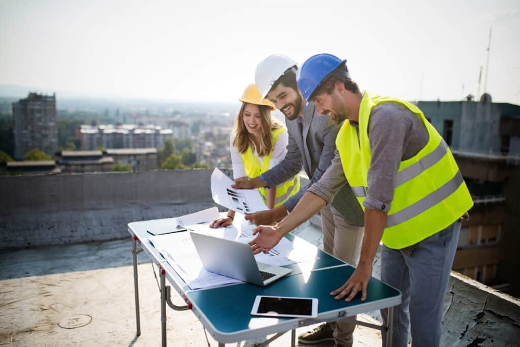 Team of architects and engineers people in group on construciton site check documents