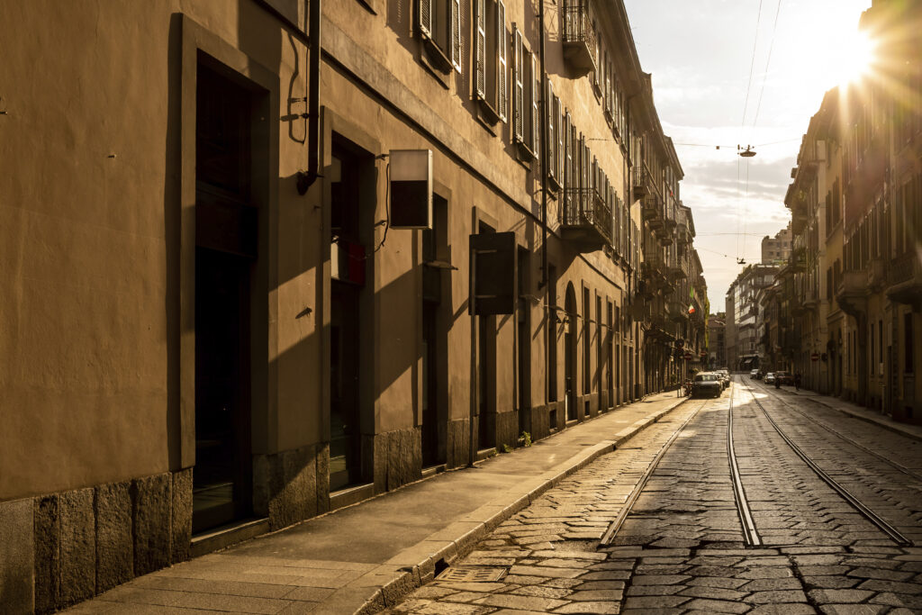 Golden hour illuminates an empty European street with tram tracks