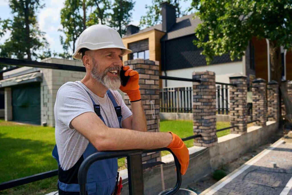 joyful-builder-talking-on-smartphone-on-constructi-2023-12-18-21-21-16-utc_11zon