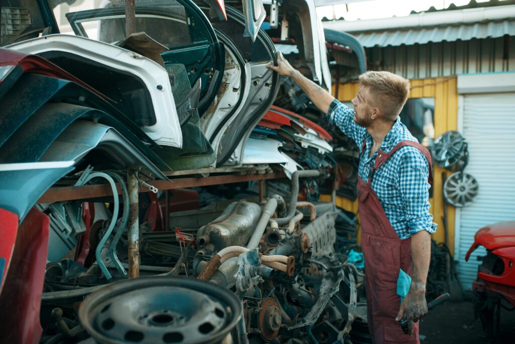 male-mechanic-choosing-door-on-car-junkyard-2023-11-27-05-07-33-utc_11zon