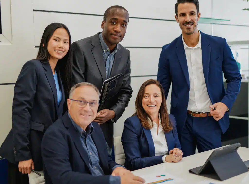 Multiracial business people smiling on camera inside modern office