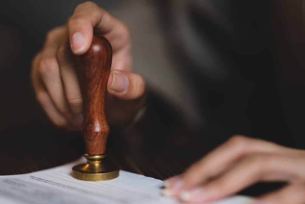 person-s-hand-stamping-with-approved-stamp-on-cert-2023-11-27-05-13-24-utc_11zon