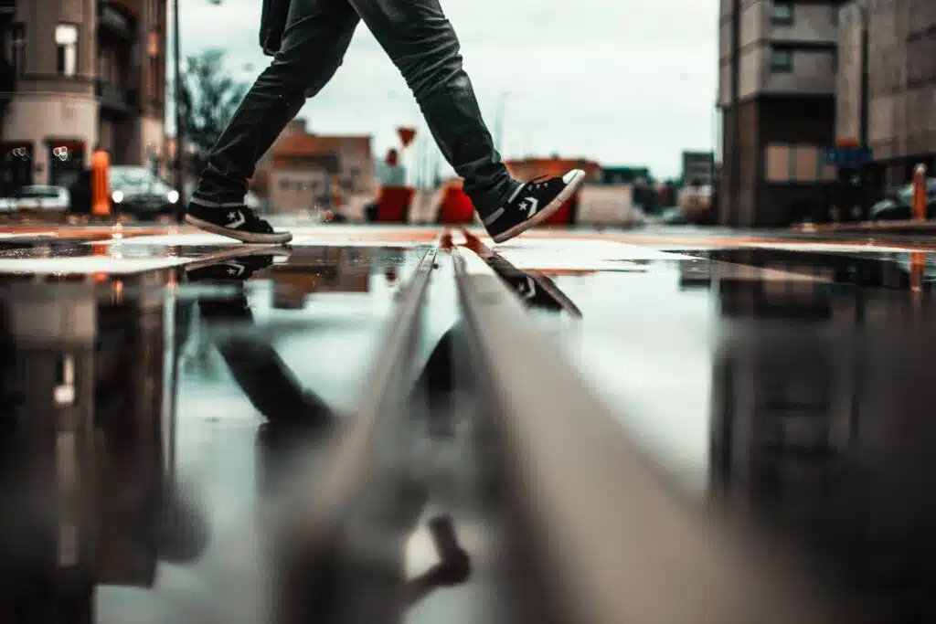 The reflection of a person's legs on the wet street captured in Poznan, Poland