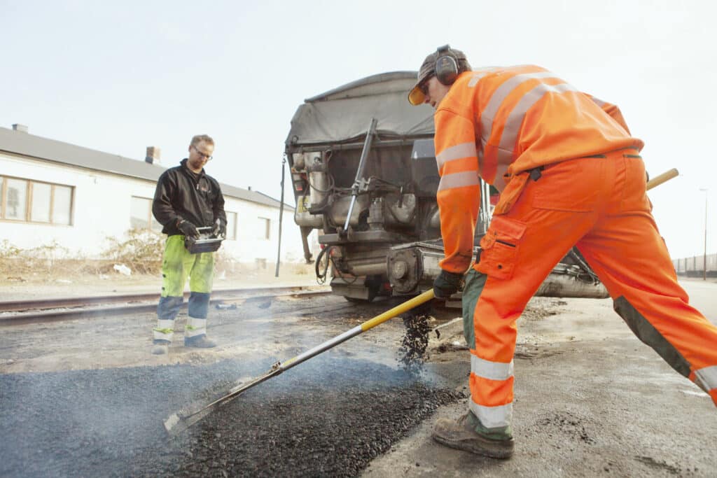 Road workers in highvisibility outfits repairing a street