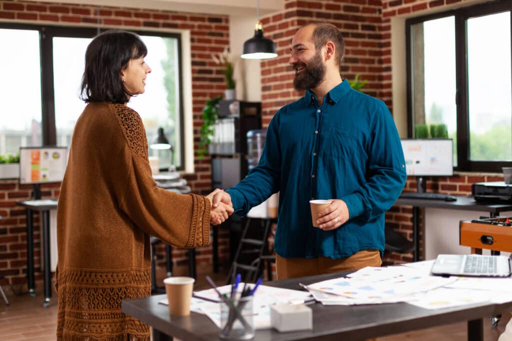 Teamwork shaking hands working at management project together planning company investment in startup office. Businesspeople analyzing marketing documents looking at strategy report