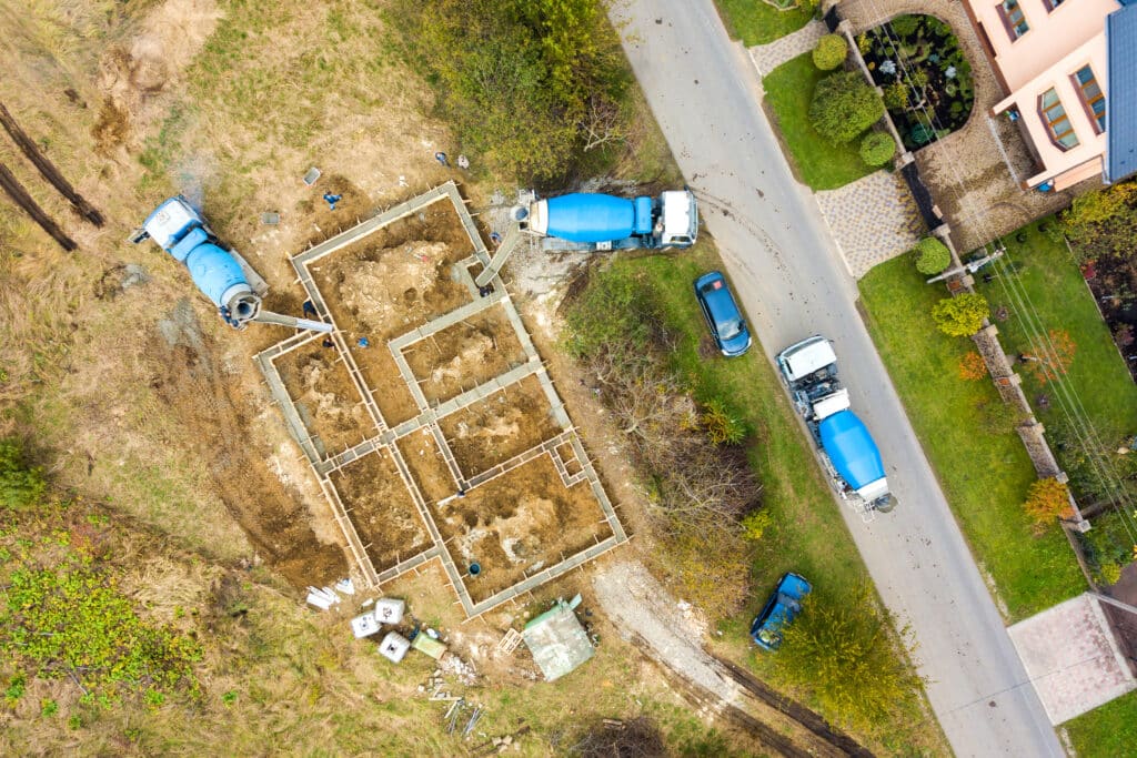 Top down aerial view of construction works of new house concrete foundation in rural residential area.