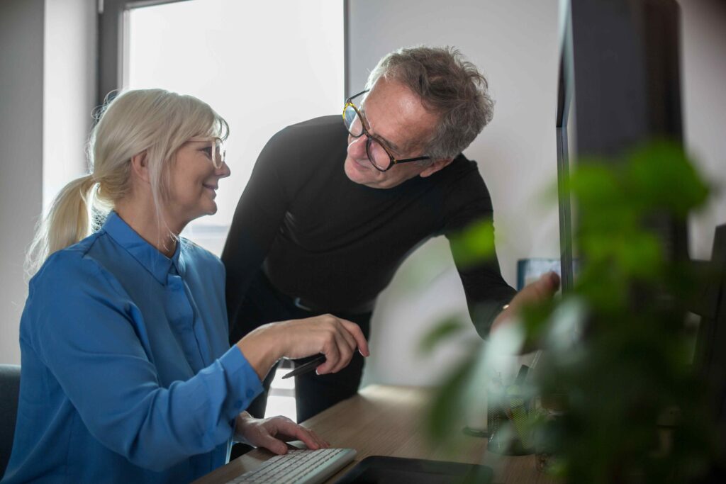 two-senior-colleagues-working-together-at-desk-in-2024-09-14-22-29-44-utc