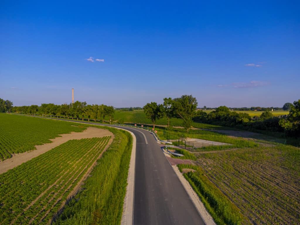 Asphalt road and fields and blue sky