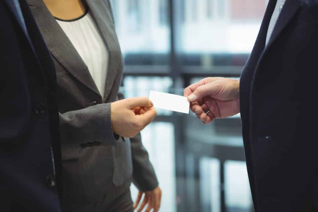 Mid-section of business executives giving business cards to each other