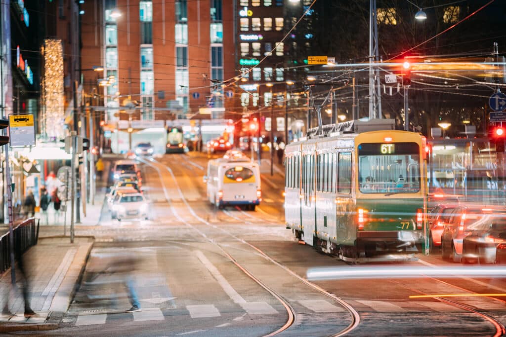 Helsinki, Finland. Tram Departs From A Stop On Kaivokatu Street In Helsinki. Night View Of Kaivokatu Street In Kluuvi District In Evening Or Night Illumination.