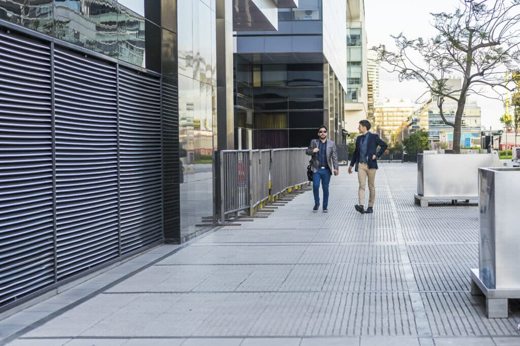 Two colleagues walking on the street while talking about the past meeting