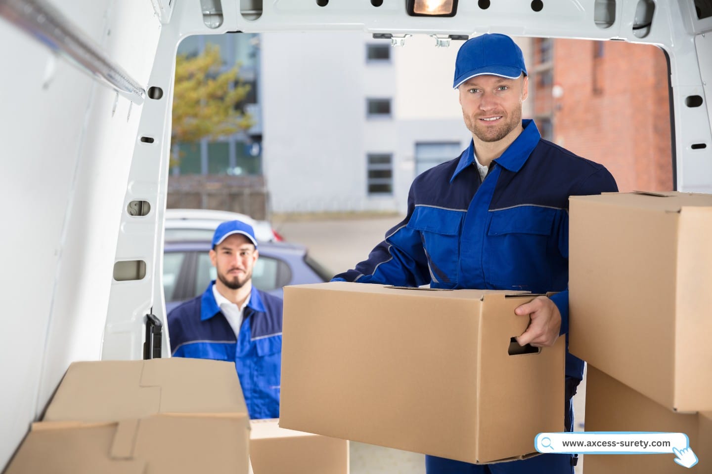 Two male mover unloading cardboard box from truck.