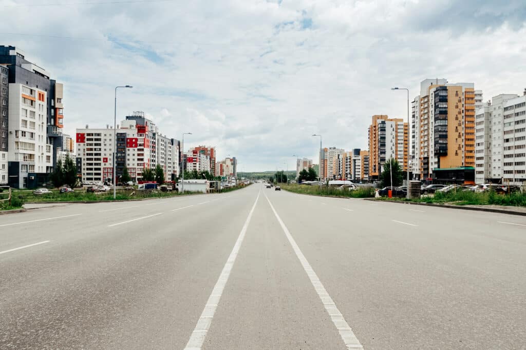 city streets with multi-storey buildings, parking and blue sky