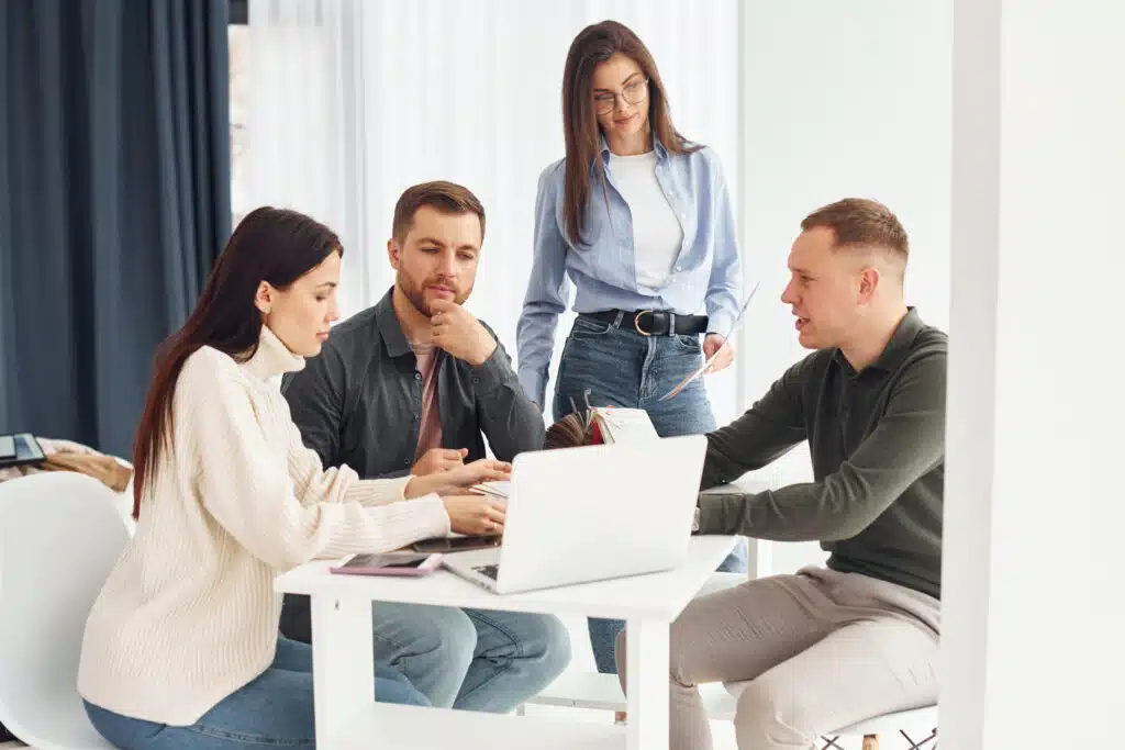 Group of people works in the office by sitting by the table.