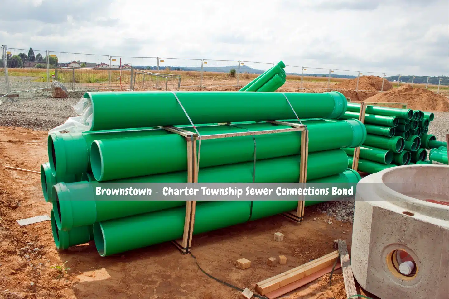 Brownstown - Charter Township Sewer Connections Bond - An exterior view of a stack of green sewer pipes on a construction site.