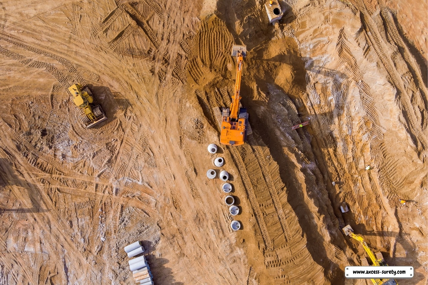An excavator digs a trench at a building site to install sewer lines.