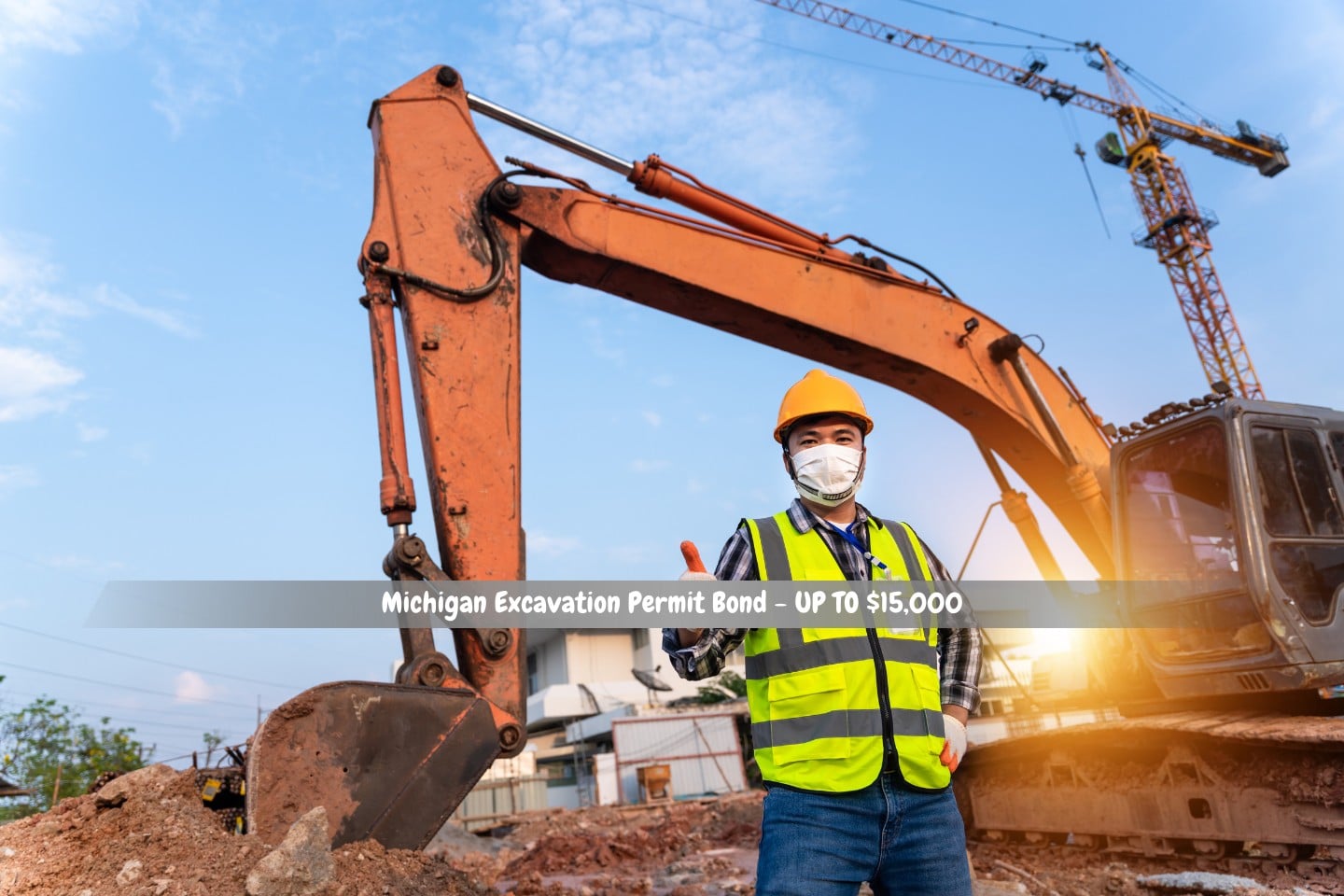 Michigan Excavation Permit Bond - UP TO $15,000 - At a construction site, a crane and backhoe operator are both dressed in safety suits.