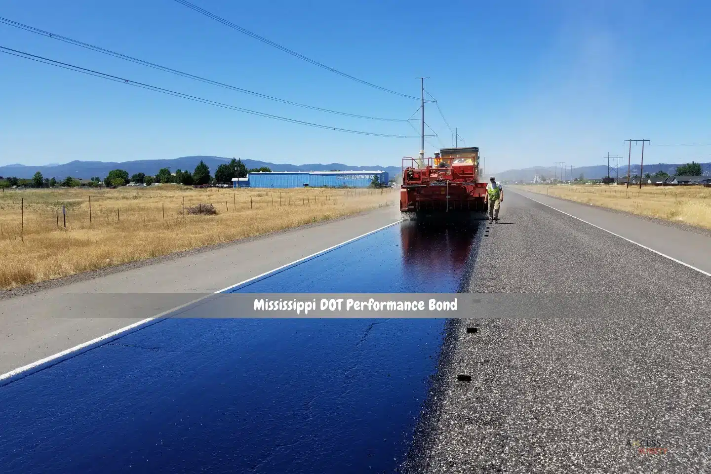Mississippi DOT Performance Bond - The road is being maintained by a machine and worker.