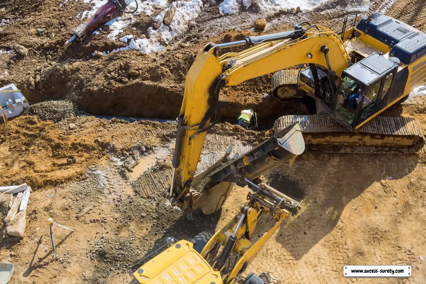 At a construction site, an excavator digs a hole to install sewer pipes and wells.