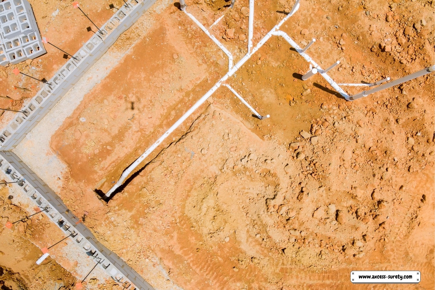 A putting water and sewer pipes underground beneath a new residential building's foundation.