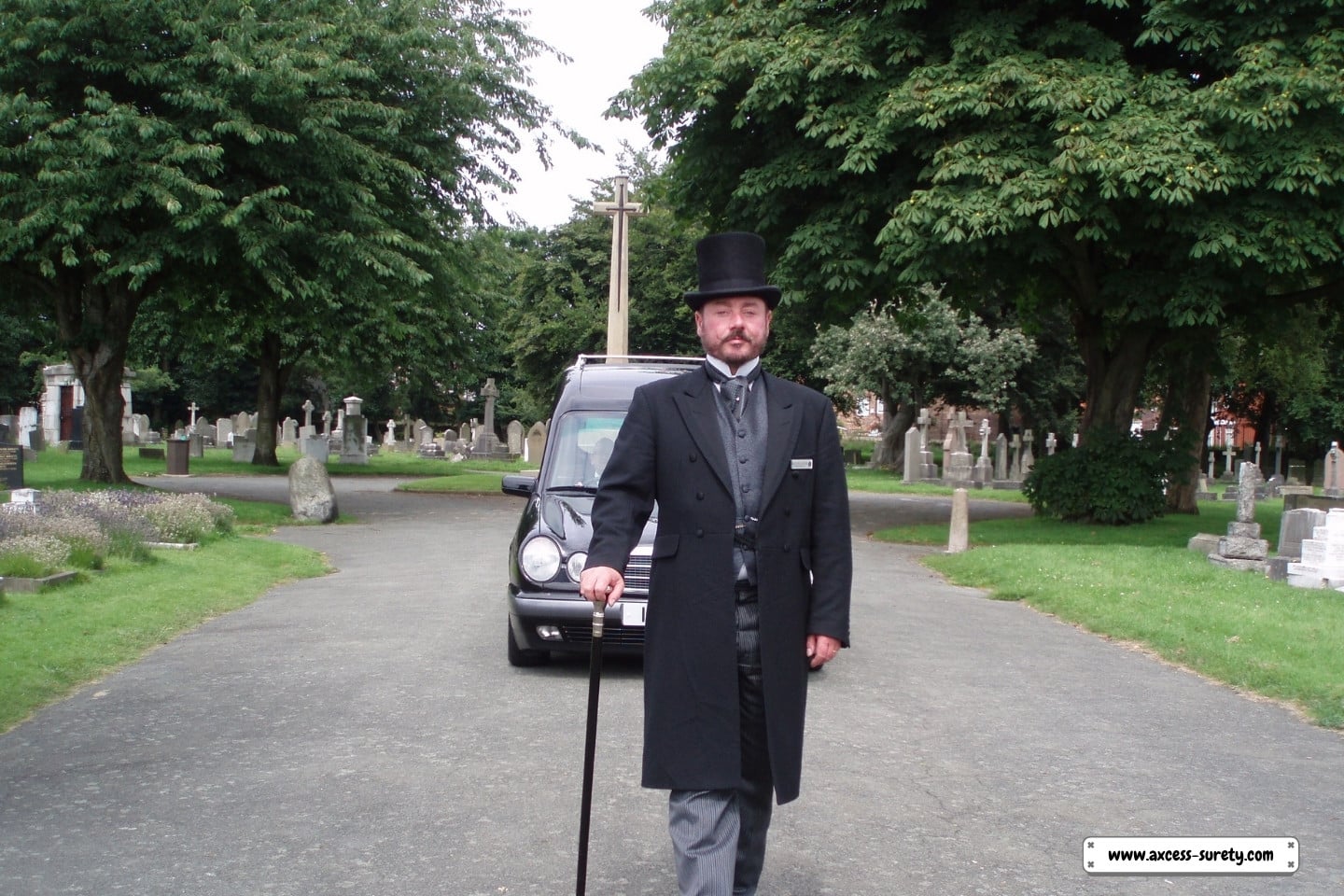 A man strolling past the funeral vehicle service.