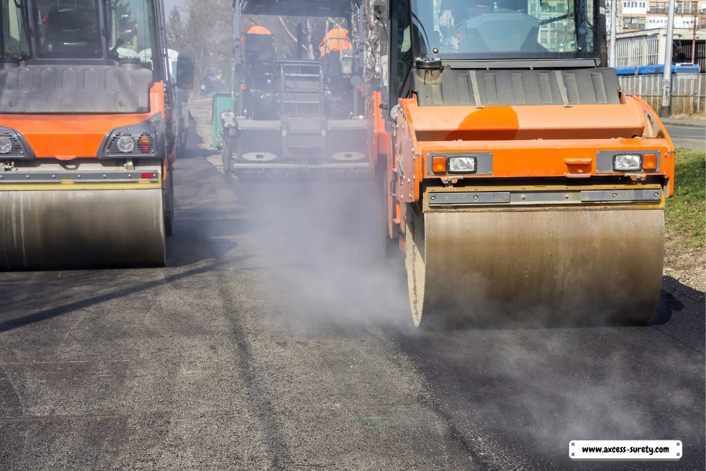 Road rollers and laborers compress asphalt roads.