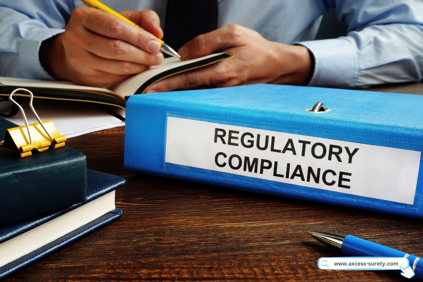 Regulatory compliance papers in the folder and manager. A guy writing on his note.