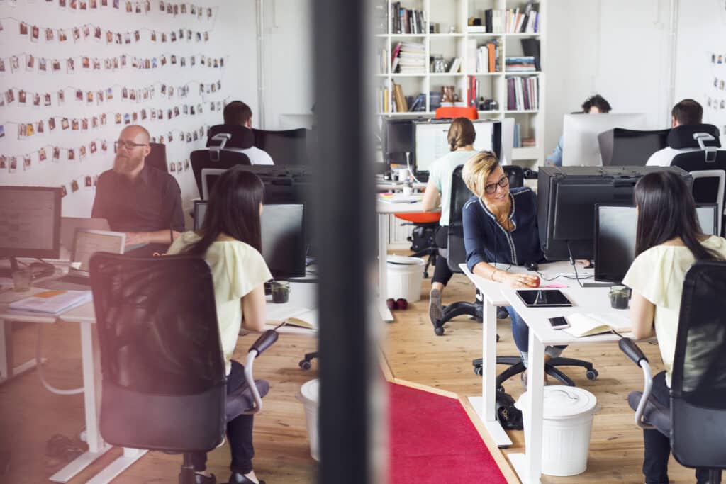 Busy office space with focused workers at their desks.