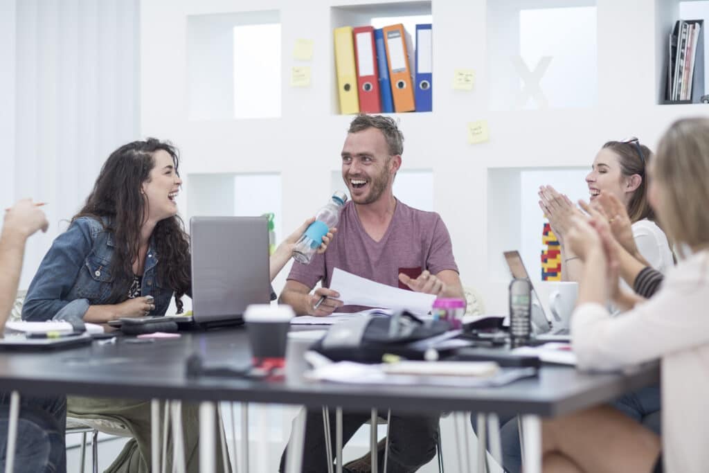 Creative office people applauding their colleague
