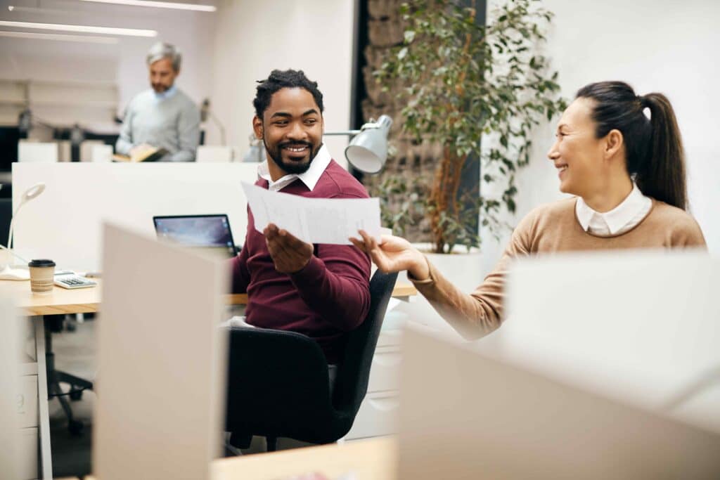 happy-colleagues-cooperating-while-working-on-busi-2023-11-27-04-51-58-utc