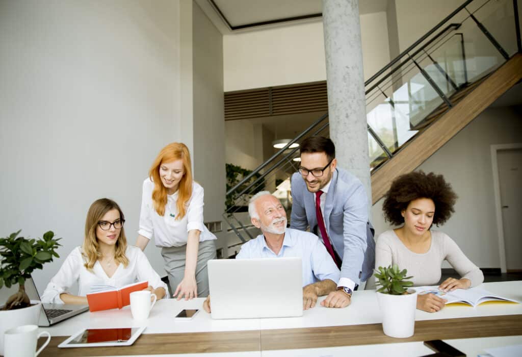 View at group of young multiracial business people around table during staff meeting in the office