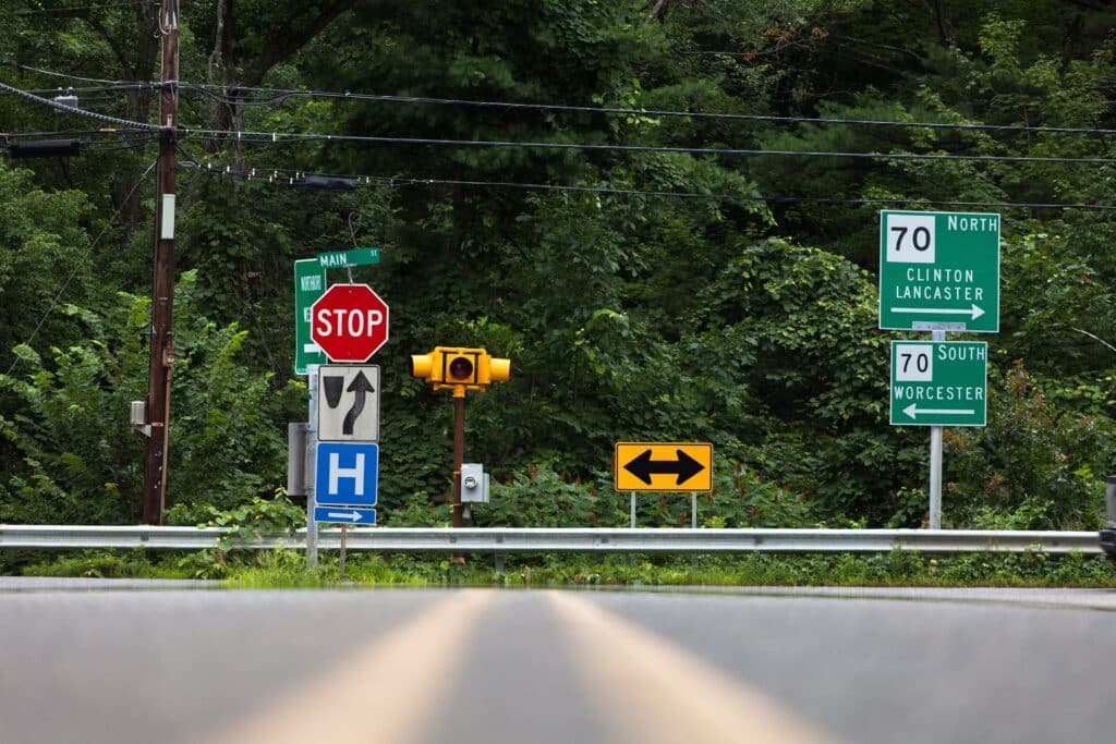 A low-angle shot of traffic signs and symbols on the side of a road