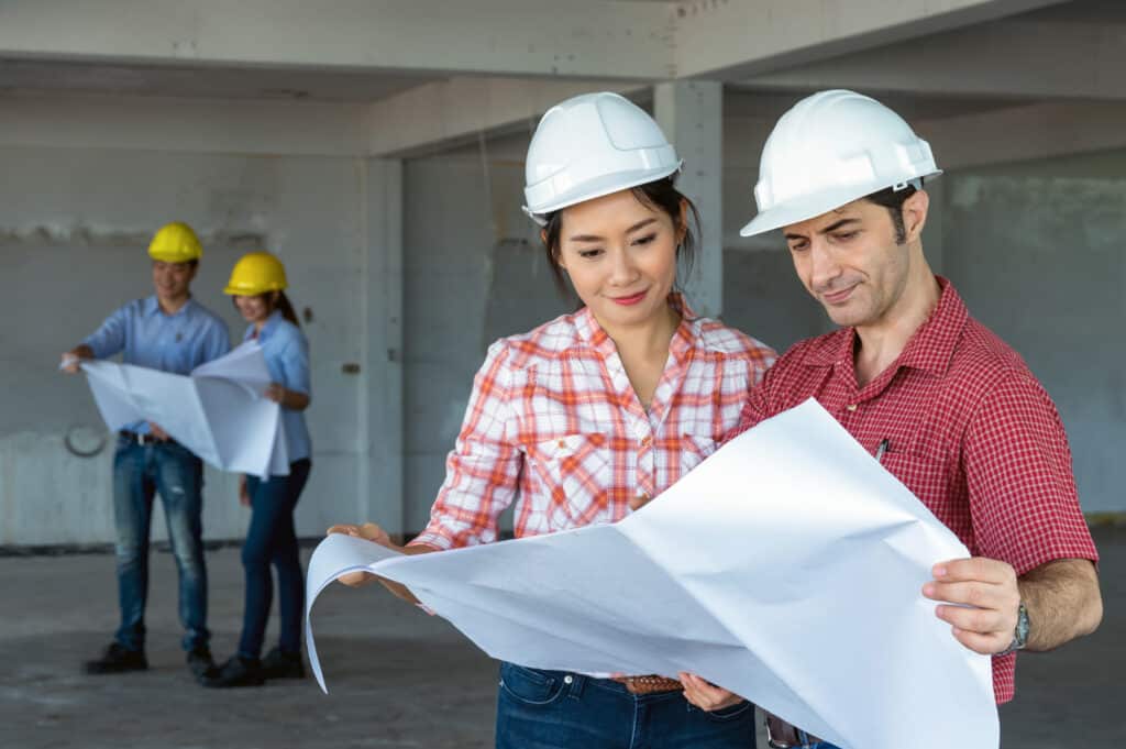 Multiethnic professional construction engineers working with Corporate Colleagues Teamwork and equipment blueprint at the building site place, Industrial engineering Concept