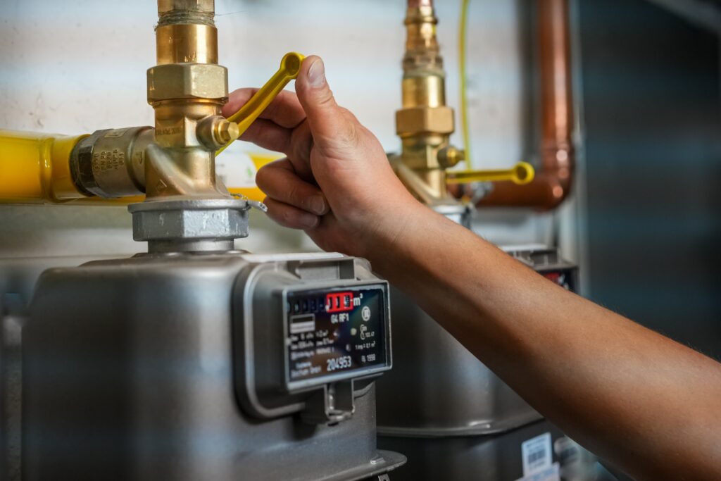 A person adjusting a gas meter to reduce gas usage - inflation, energy crisis in Europe concept
