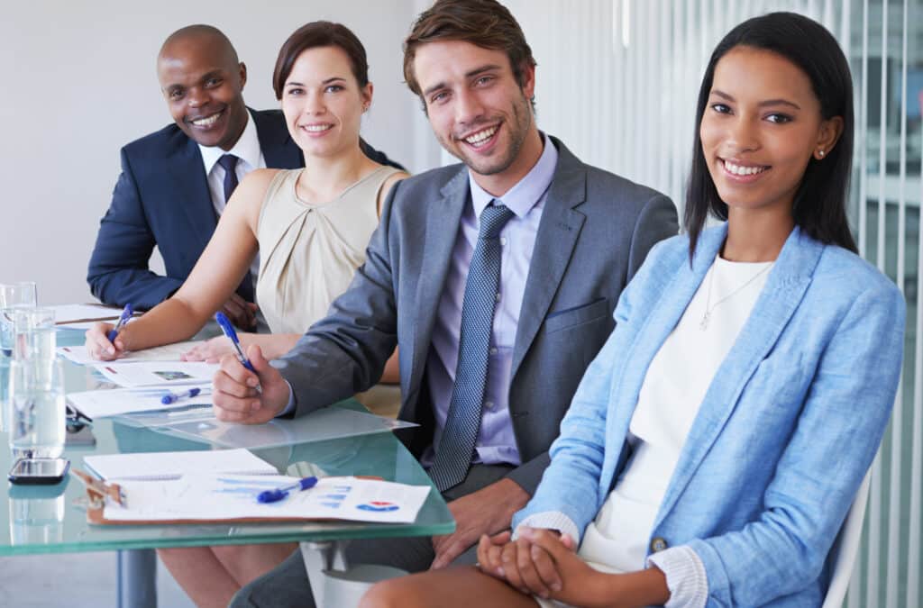 Portrait of a group of businesspeople sitting at a conference table.